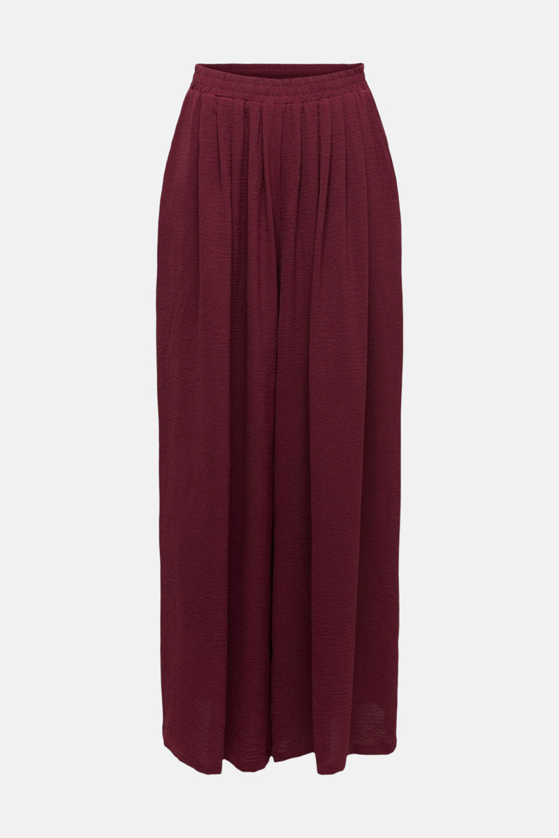 Pantalon bordeaux de JDY, à plis souples et à texture subtile, présenté sur fond neutre.
