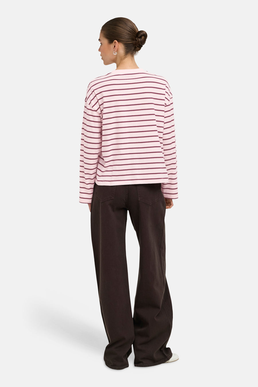 Pale lilac long-sleeve striped T-shirt with burgundy horizontal stripes, back view on model wearing dark wide-leg pants