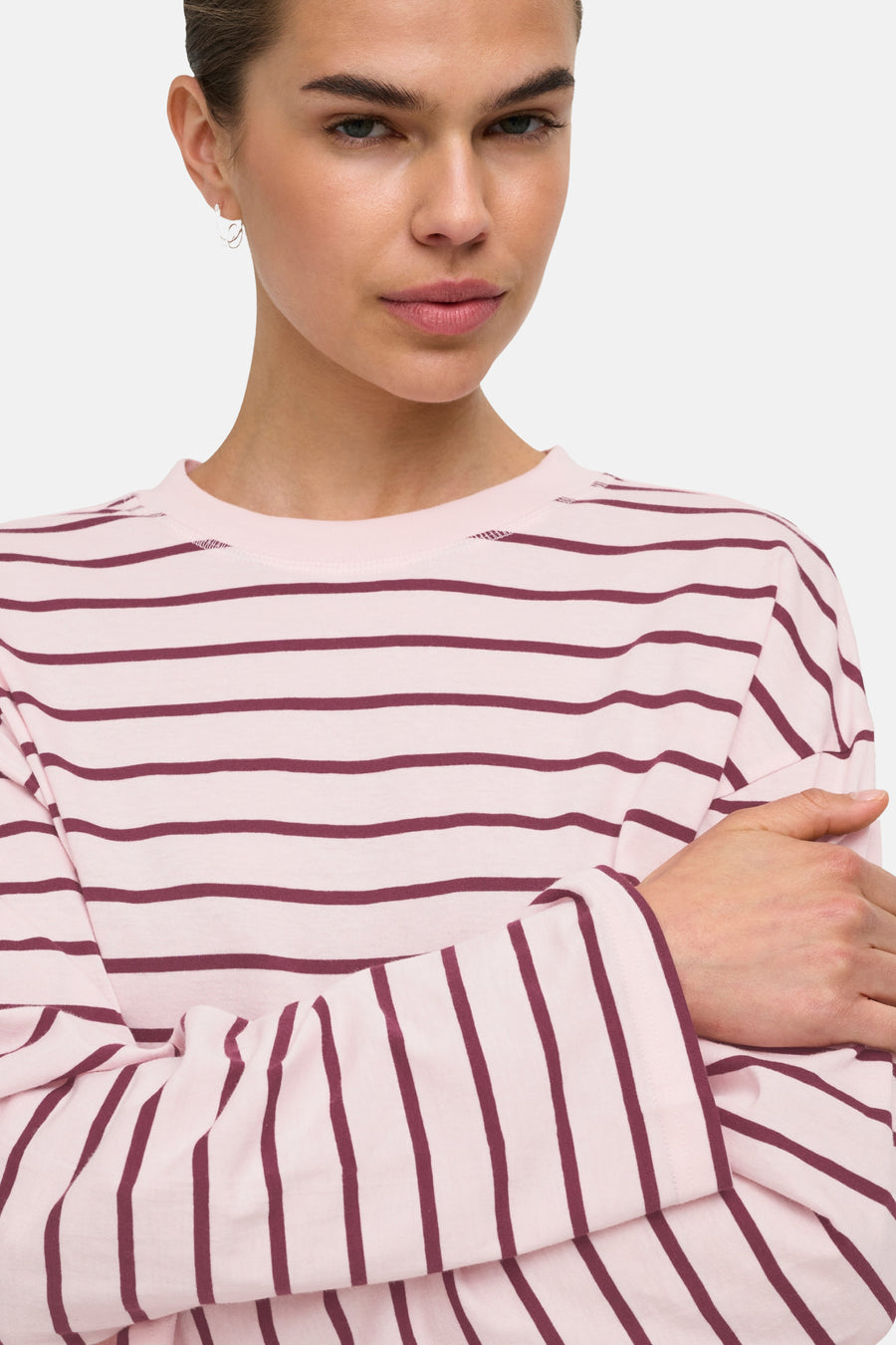 Pale lilac long-sleeve t-shirt with burgundy horizontal stripes, round neckline, and soft knit texture, shown in close-up front view on model.