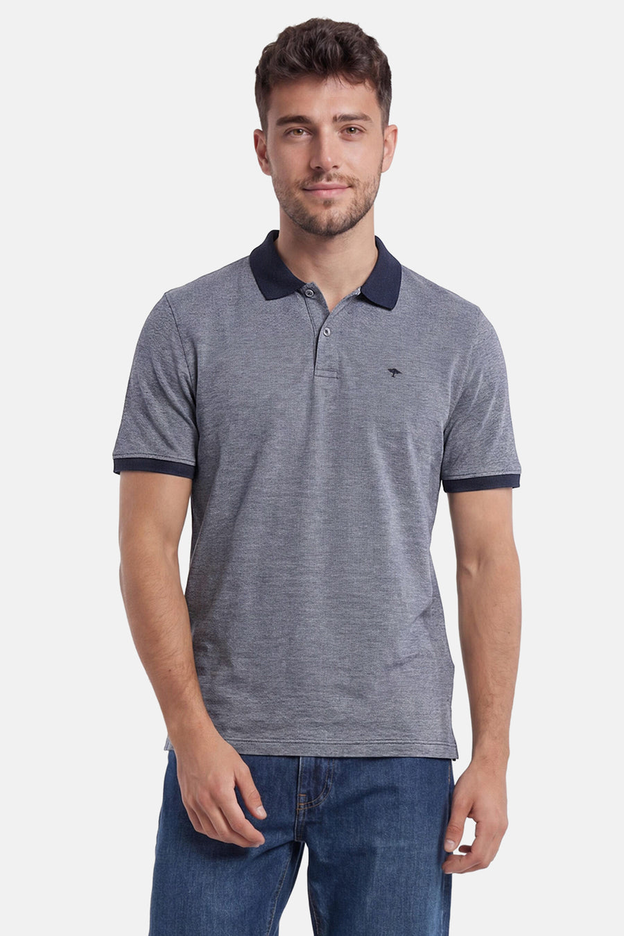 Polo bleu texturé de FYNCH-HATTON avec col et bordures marine, petit logo arbre, porté par un homme en jean.