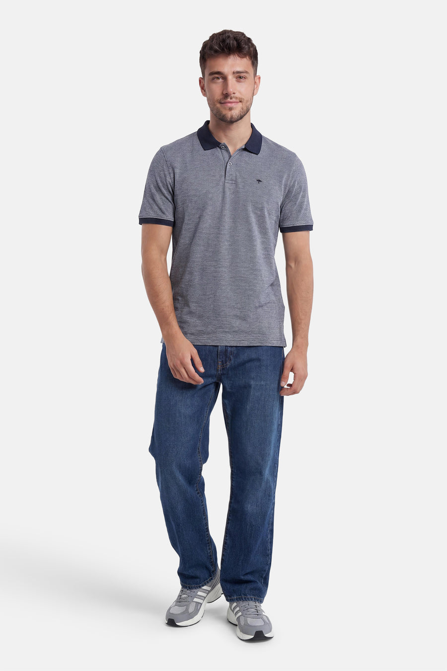 Polo bleu chiné de FYNCH-HATTON avec logo kangourou, col et bords de manches marine, porté avec un jean.