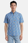Chemise à manches courtes multicolore de FYNCH-HATTON à motif floral bleu, orange et vert, portée avec un jean clair.