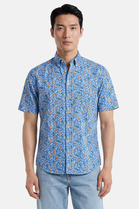 Chemise à manches courtes multicolore de FYNCH-HATTON à motif floral bleu, orange et vert, portée avec un jean clair.