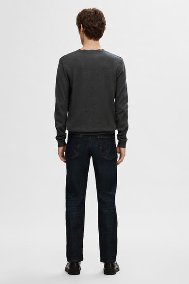 Pull col rond gris de SELECTED, porté avec un jean bleu foncé et des chaussures noires, vue de dos.

