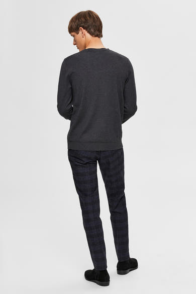 Pull gris par SELECTED, avec un motif uniforme, porté avec un pantalon à carreaux et des chaussures noires.