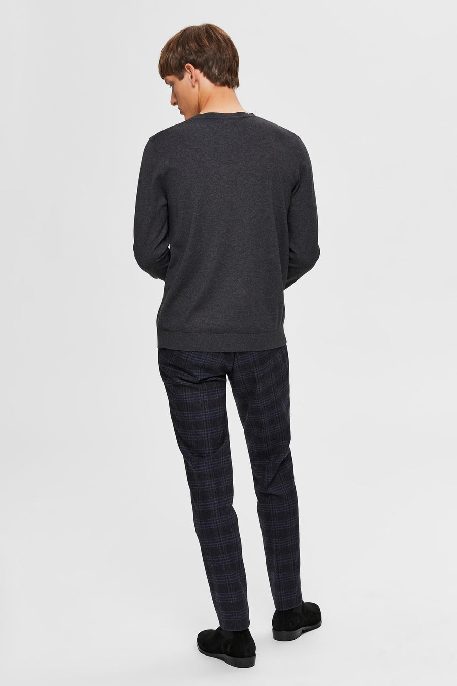 Pull gris par SELECTED, avec un motif uniforme, porté avec un pantalon à carreaux et des chaussures noires.