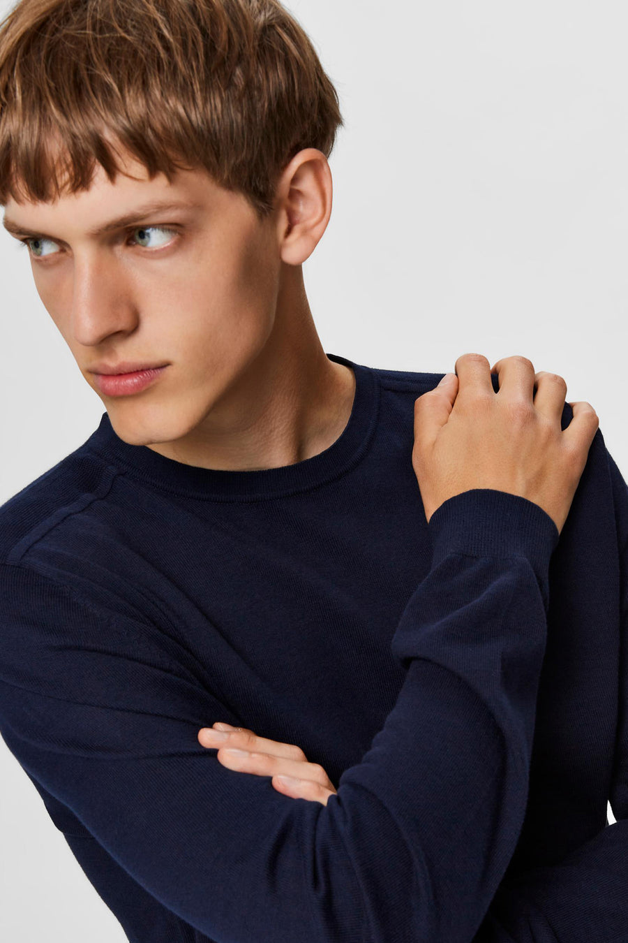 Pull bleu de SELECTED, en maille fine, porté par un homme aux cheveux châtain clair.