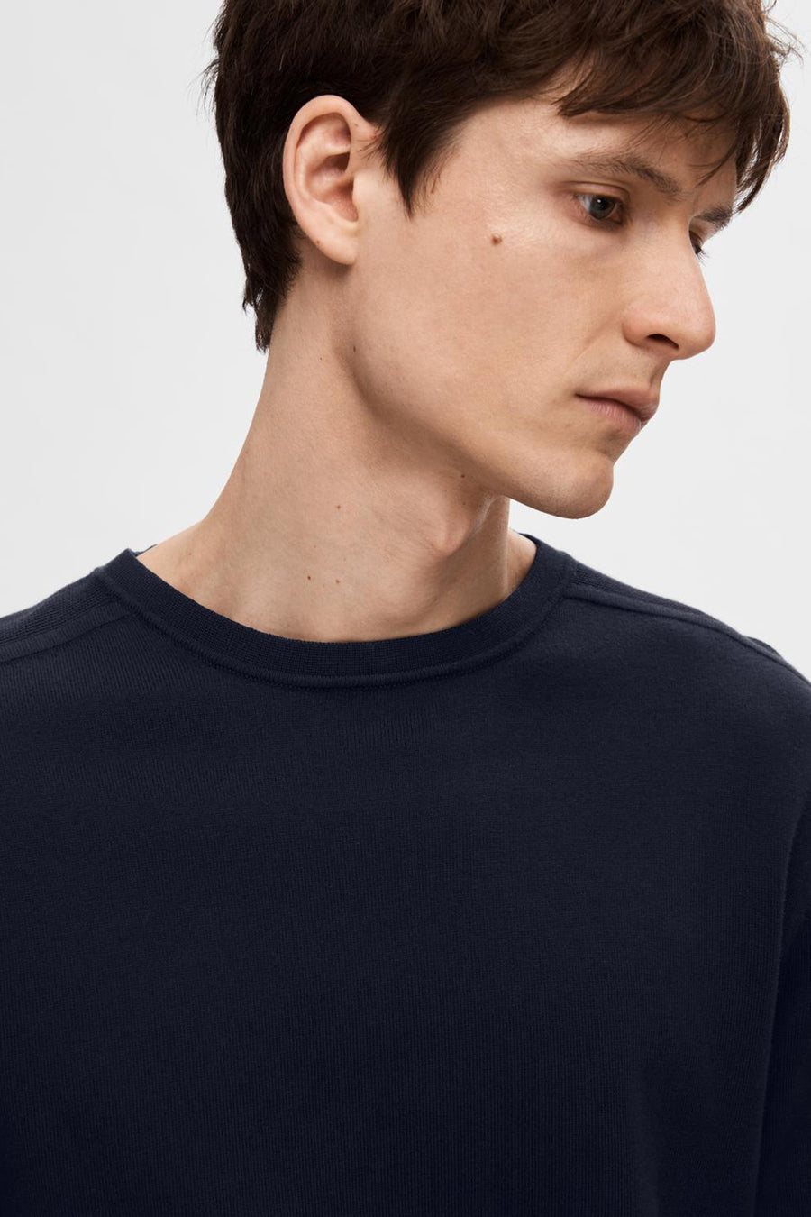 Pull bleu marine SELECTED avec une texture tricotée fine, porté avec un col rond.