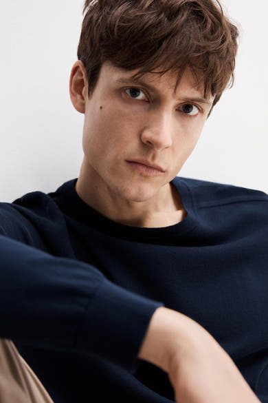 Pull ras du cou bleu de SELECTED, porté par un homme aux cheveux bruns.