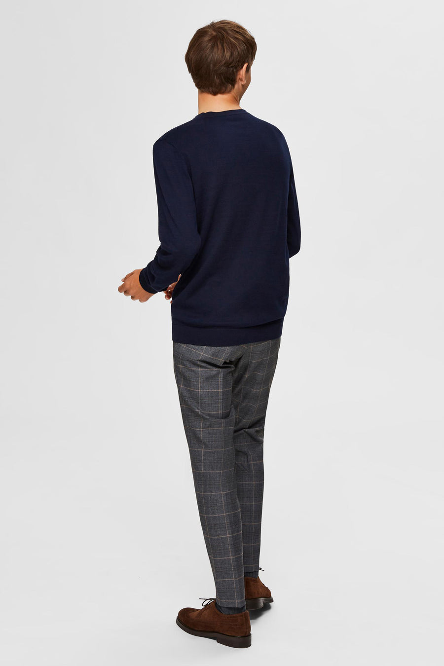 Pull bleu SELECTED, porté avec un pantalon à carreaux et des chaussures marron, vue de dos.