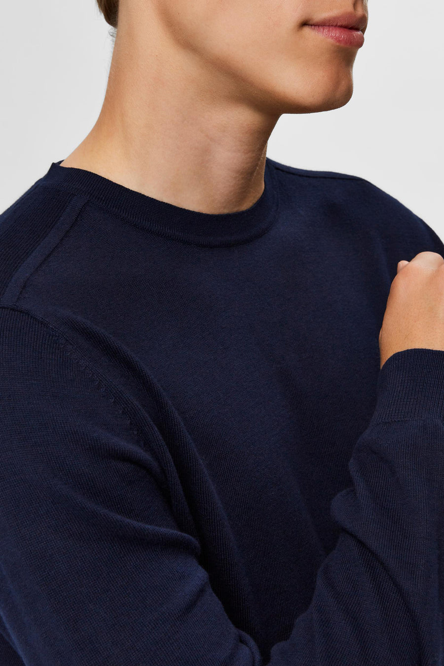 Pull bleu col rond de SELECTED, montrant la texture du tricot et la forme du col.