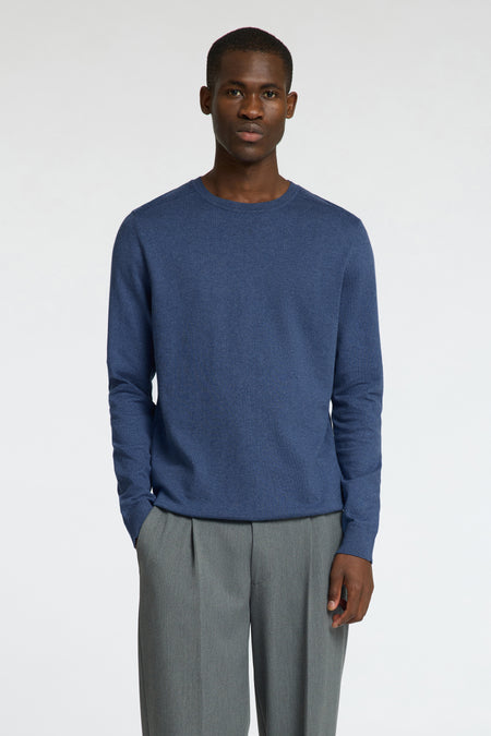 Ronde hals trui blauw van SELECTED, gedragen met een grijze plooibroek en zwarte loafers.