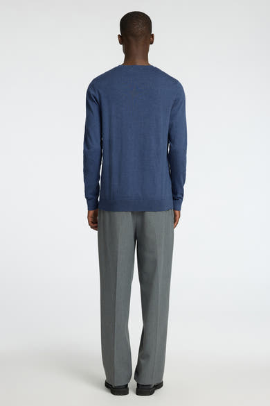 Pull à col rond bleu de SELECTED, porté avec un pantalon gris et des chaussures noires.