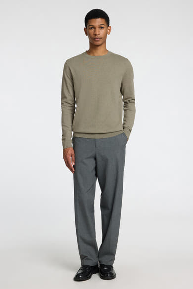 Pull vert de SELECTED, porté avec un pantalon gris et des chaussures noires.