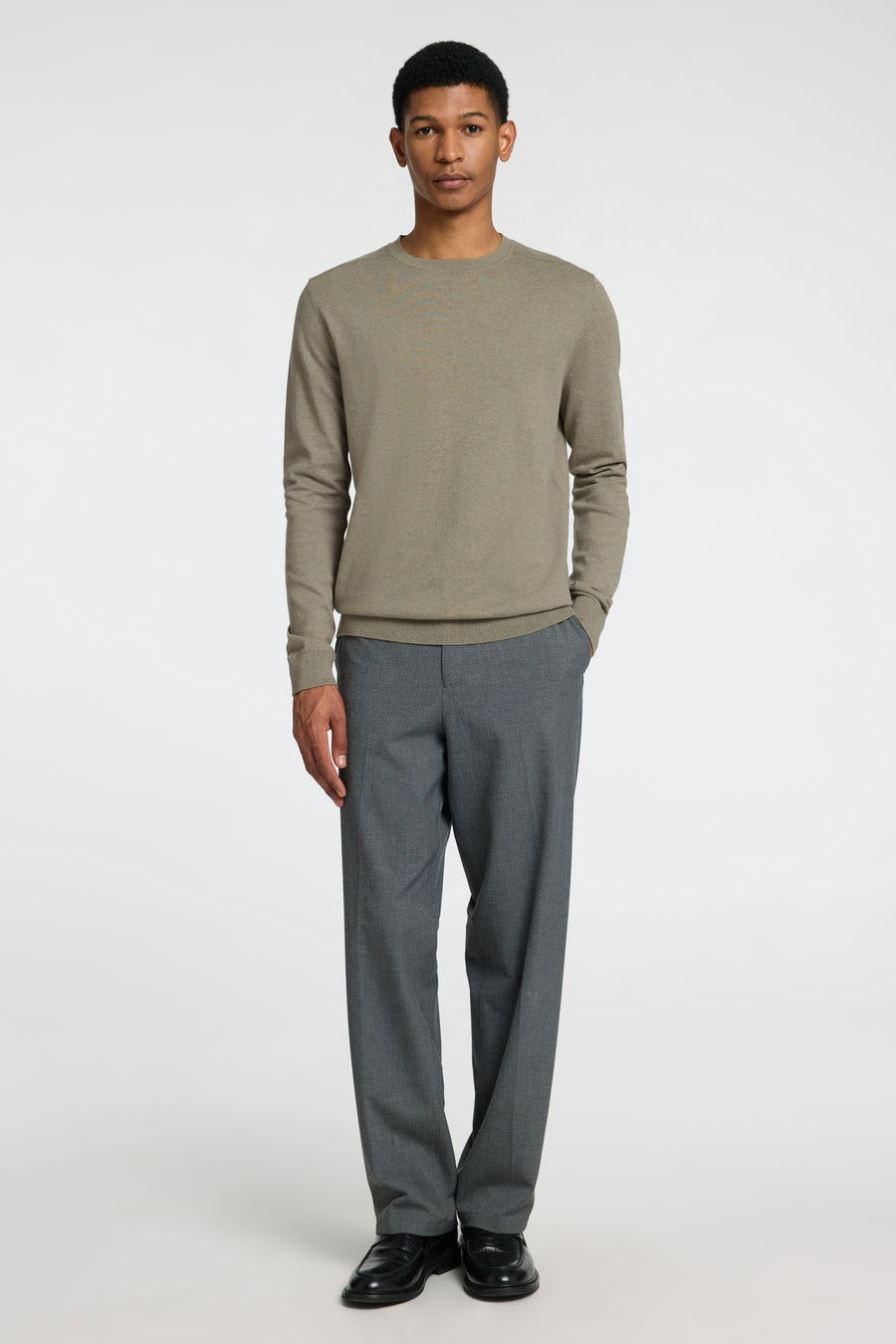 Pull vert de SELECTED, porté avec un pantalon gris et des chaussures noires.