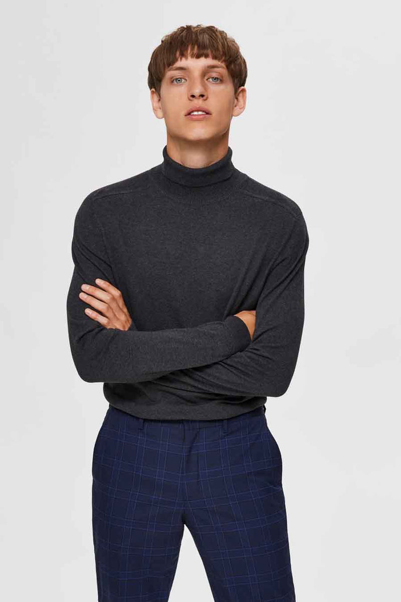 Grijze coltrui van SELECTED, gedragen met een marineblauwe geruite broek.