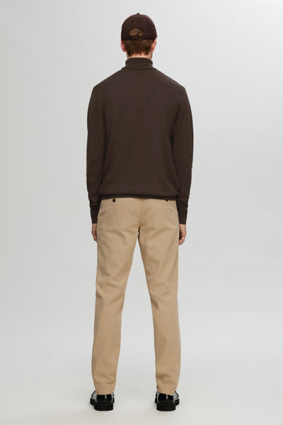 Pull à col roulé brun de SELECTED, porté avec un pantalon beige et des chaussures noires, vue de dos.