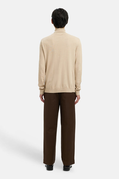 Beige coltrui van SELECTED, gedragen met een bruine broek en zwarte schoenen, achterzicht.
