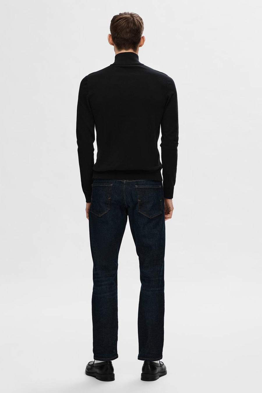 Pull noir col roulé de SELECTED, porté avec un jean brut et des mocassins noirs.