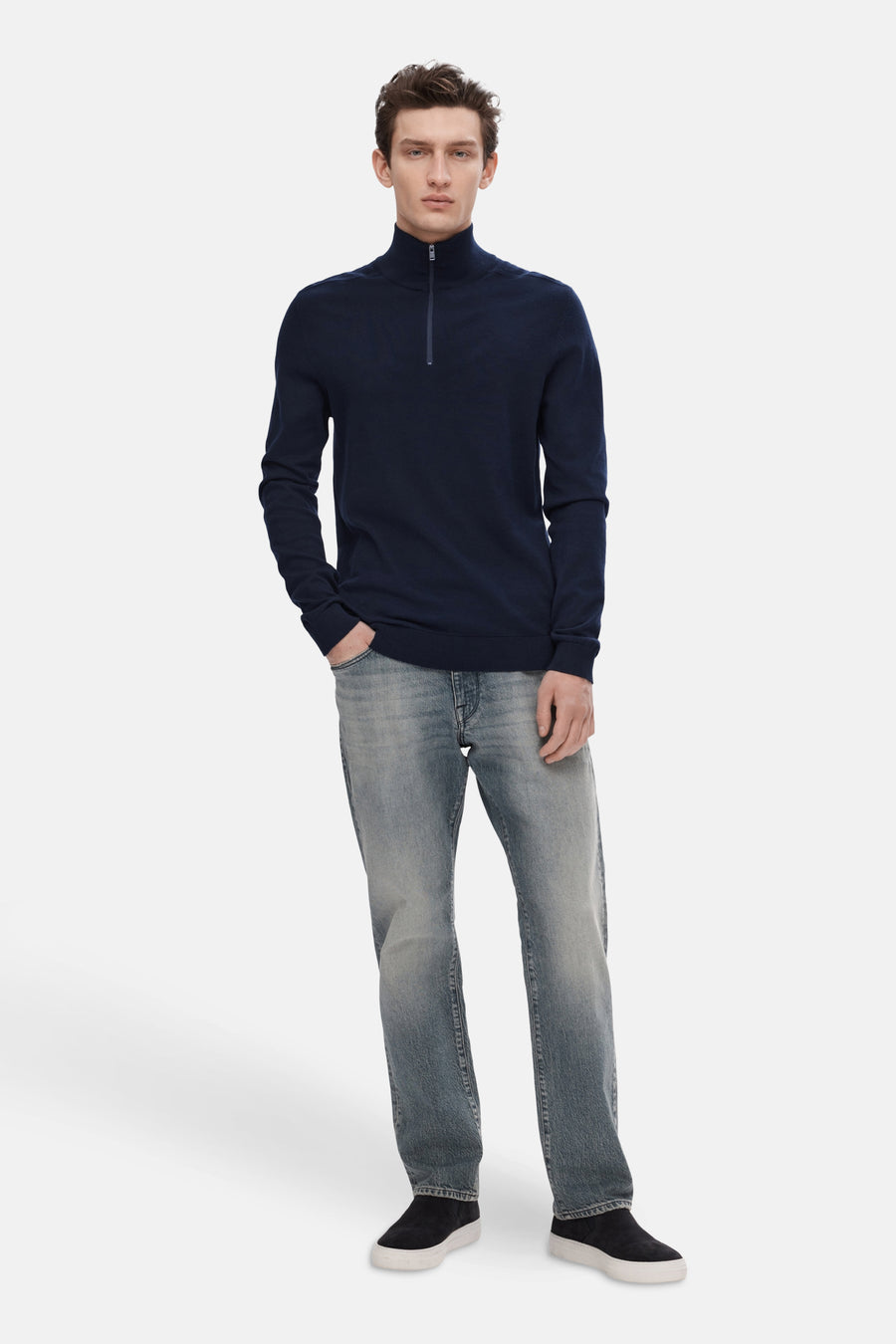 Pull bleu à demi-zip de SELECTED, porté avec un jean délavé et des chaussures noires.
