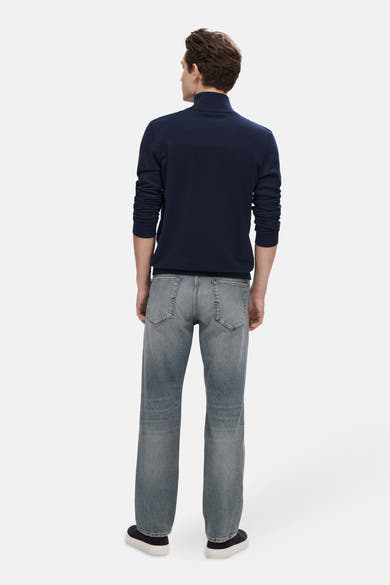 Pull bleu de SELECTED, col montant, porté avec un jean délavé et des chaussures noires à semelles blanches, vue de dos.