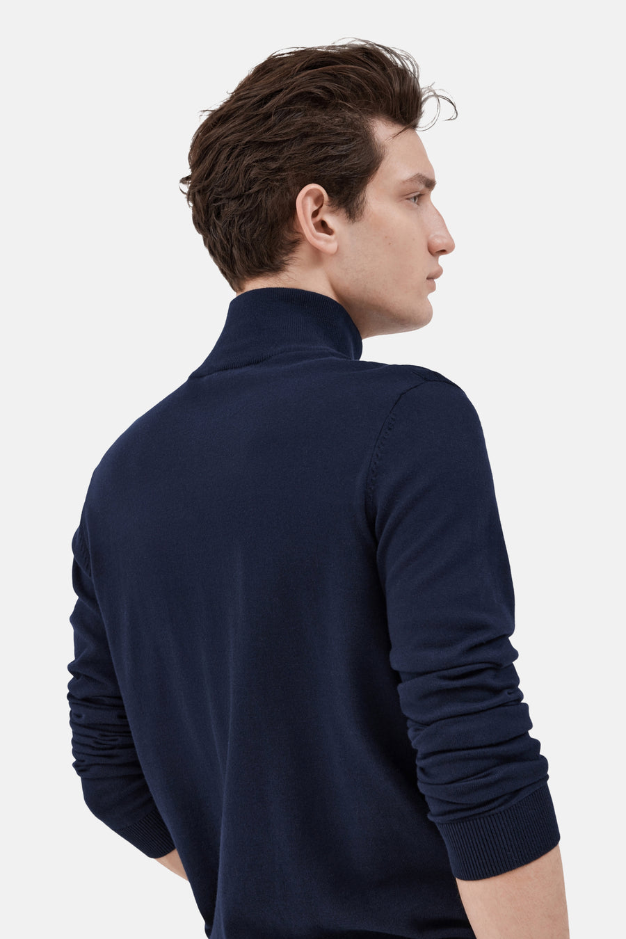 Pull col roulé bleu de SELECTED, porté par un homme de profil, sur fond uni.