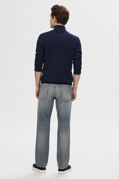 Pull bleu SELECTED, porté avec un jean gris délavé et des chaussures de sport noires, vue de dos.