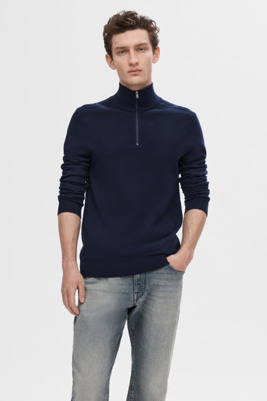 Pull bleu de SELECTED, porté avec un jean décontracté, homme avec main dans la poche.
