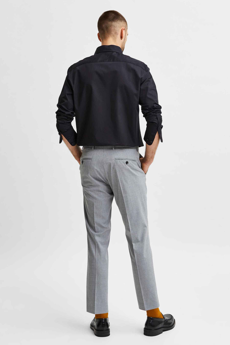 Zwart overhemd met lange mouwen van SELECTED, gedragen met een grijze broek en feloranje sokken.