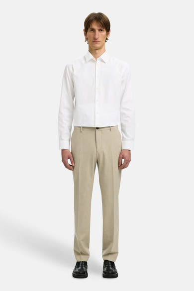 Chemise à manches longues blanche de SELECTED, portée avec un pantalon beige et des mocassins noirs.