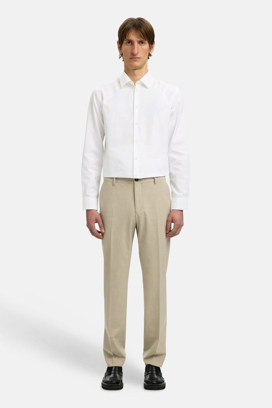 Chemise à manches longues blanche de SELECTED, portée avec un pantalon beige et des mocassins noirs.
