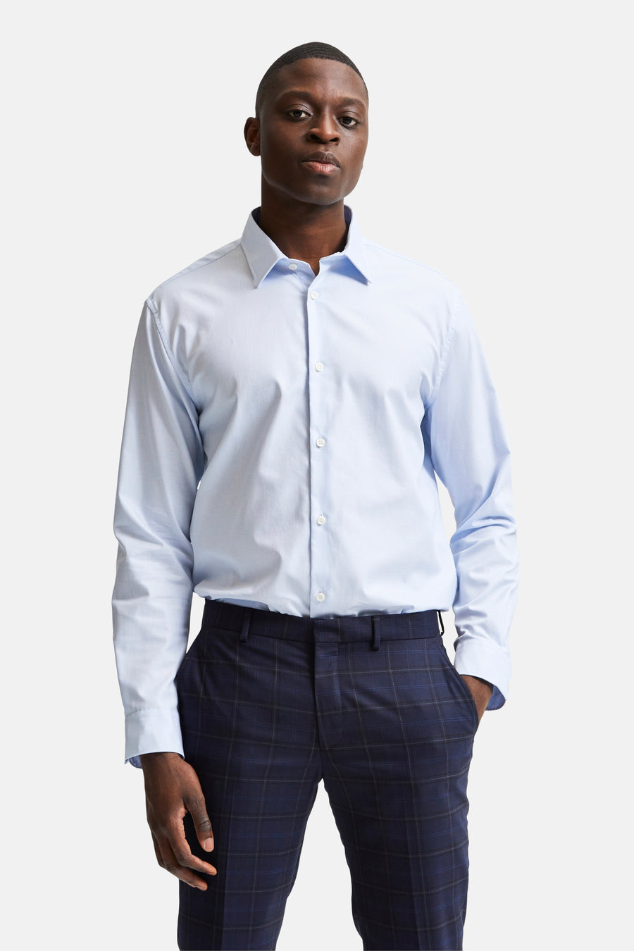 Chemise à manches longues bleue de SELECTED, portée avec un pantalon à carreaux bleu marine.