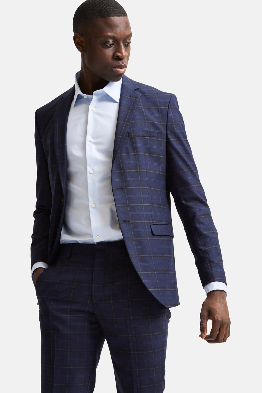 Blauw overhemd met lange mouwen van SELECTED, gedragen onder een geruit kostuumjasje.