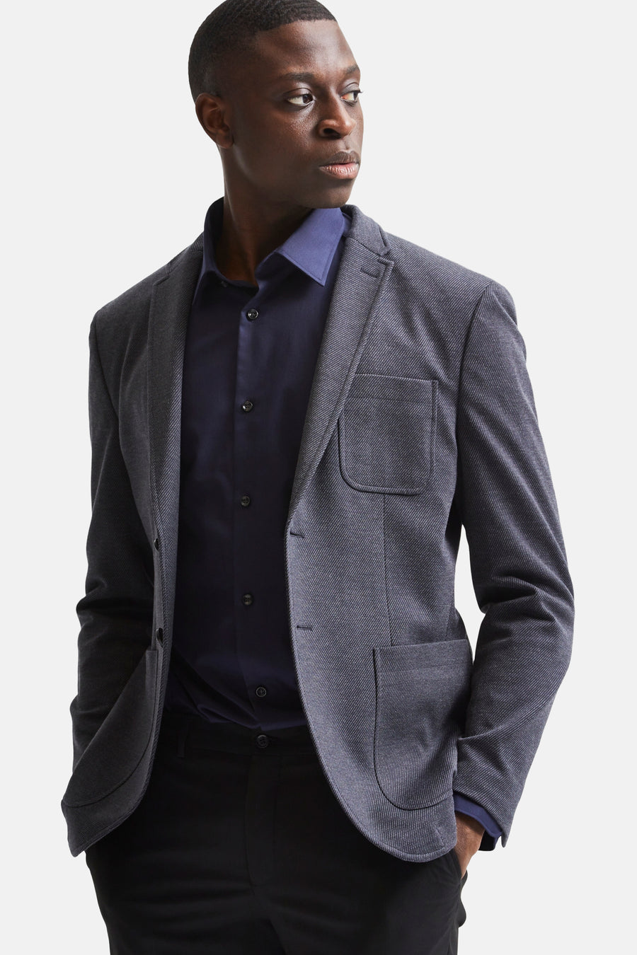 Blauw overhemd met lange mouwen van SELECTED, gedragen met een getextureerd kostuumjasje, op een zwarte broek.