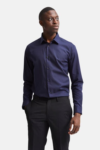 Blauwe blouse met lange mouwen van SELECTED, gedragen met een zwarte broek, man kijkt opzij.