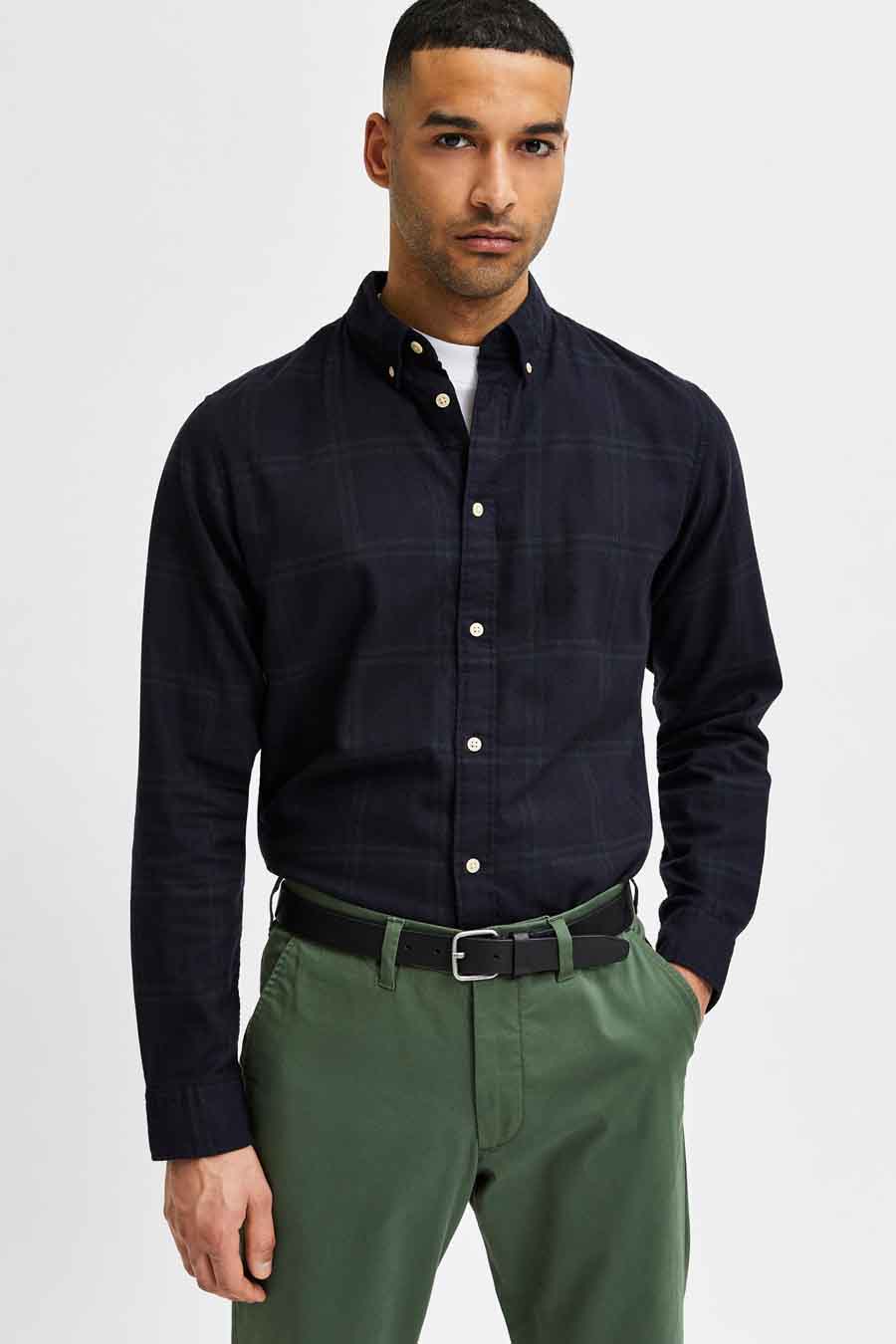 Zwarte leren riem van SELECTED, met een zilveren gesp en gedragen met een groene broek.