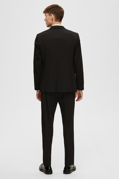 Zwarte blazer van SELECTED, van achteren gezien, met bijpassende zwarte broek en schoenen.