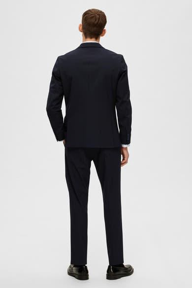 Blazer bleu marine de SELECTED, vu de dos, porté sur une chemise blanche et un pantalon assorti.