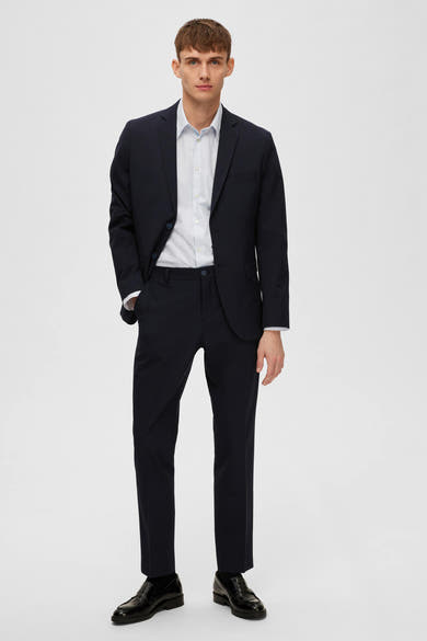Blazer bleu de SELECTED, porté avec une chemise à motif et des chaussures noires classiques.