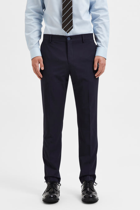 Pantalon de costume bleu par SELECTED, porté avec une chemise bleu clair et une cravate rayée.