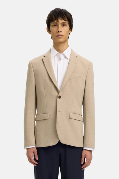 Beige blazer van SELECTED, gedragen over een wit overhemd met knopen en een donkere broek.
