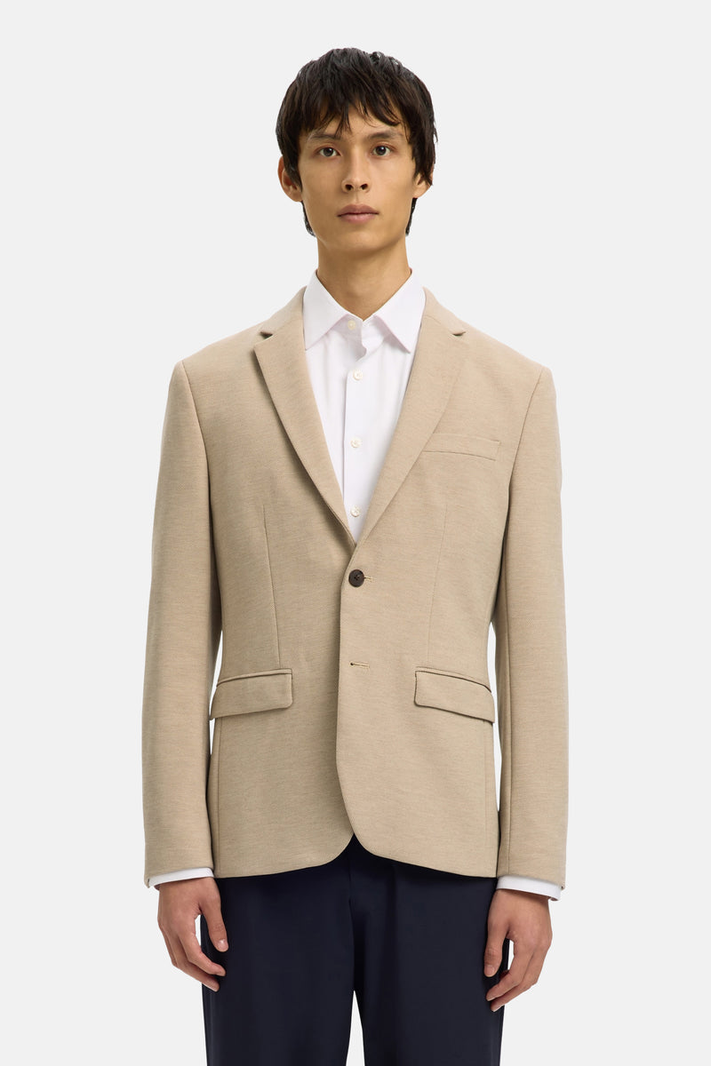 Beige blazer van SELECTED, gedragen over een wit overhemd met knopen en een donkere broek.