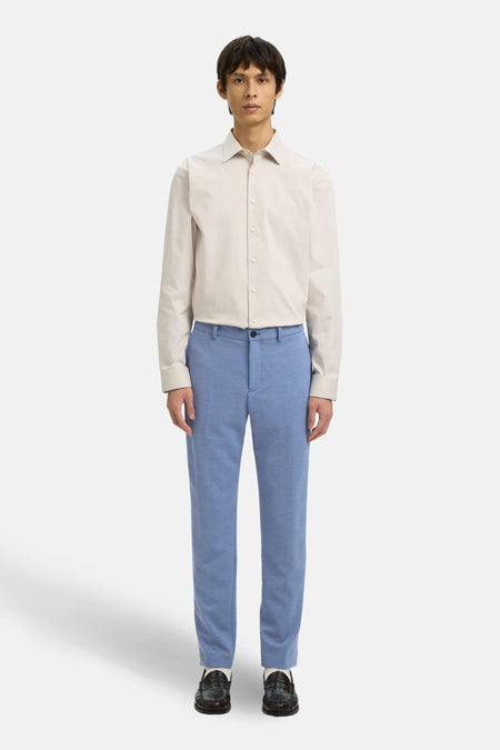 Pantalon de costume bleu SELECTED, avec une texture subtile, porté avec une chemise beige et des mocassins noirs.
