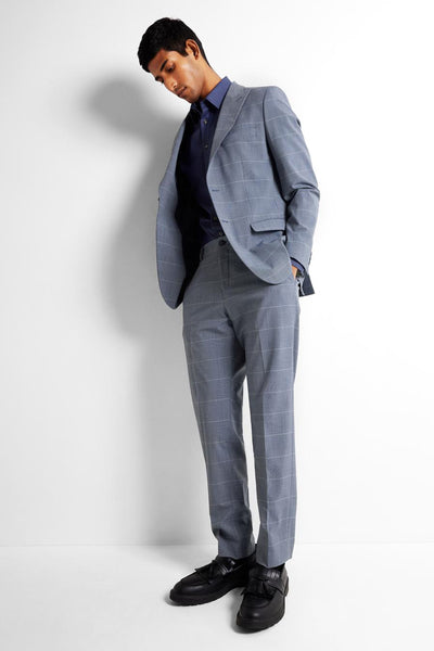 Pantalon de costume bleu SELECTED, à carreaux discrets, porté avec une chemise bleu foncé et des chaussures noires à glands.