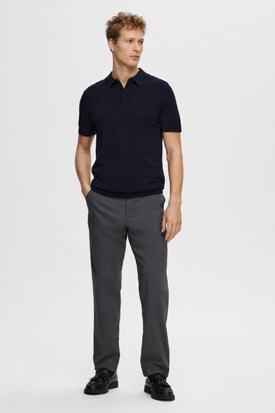 Polo à manches courtes bleu de SELECTED, porté avec un pantalon gris et des chaussures noires à franges.