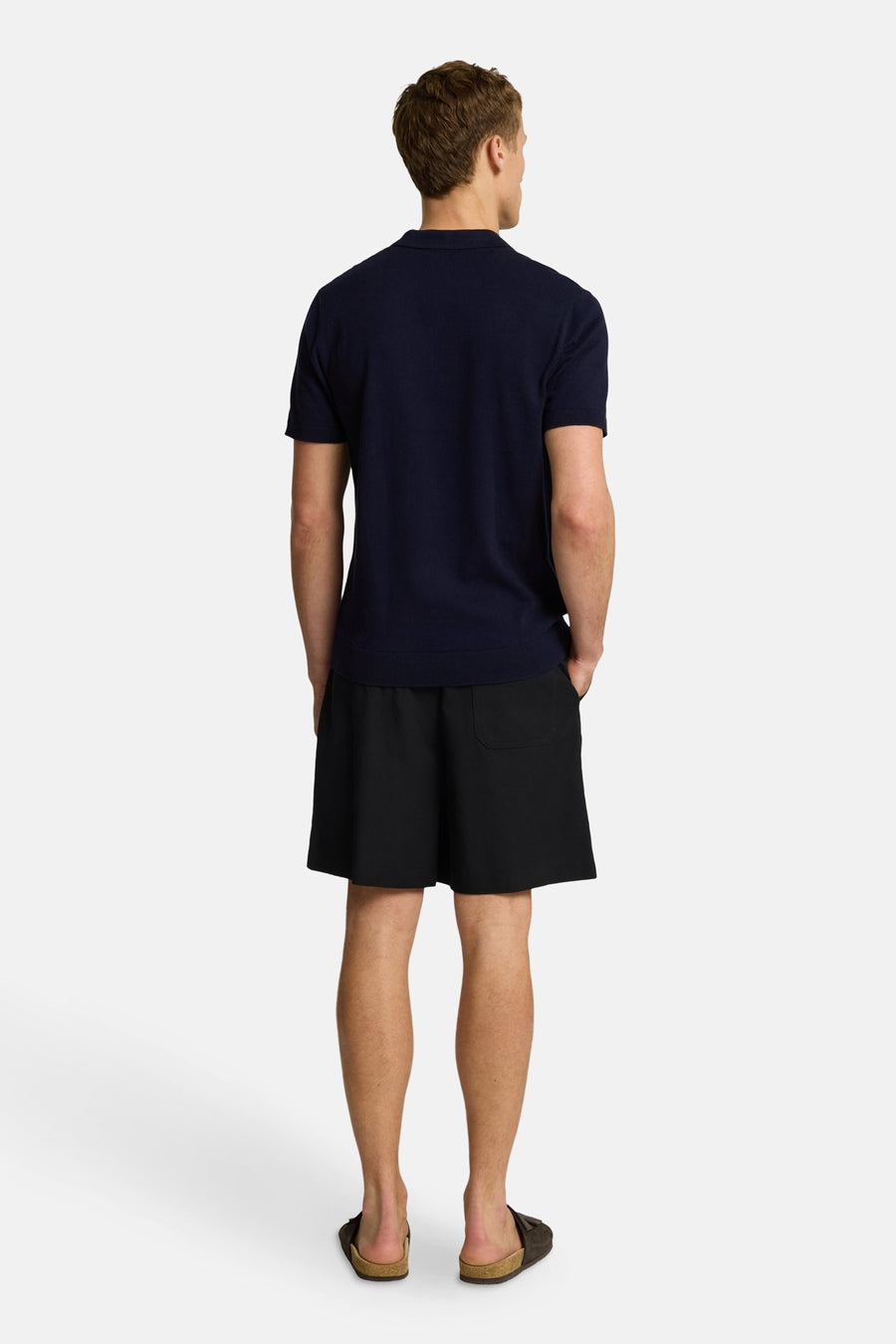 Polo bleu à manches courtes de SELECTED, porté avec un short noir et des sandales, vue de dos.