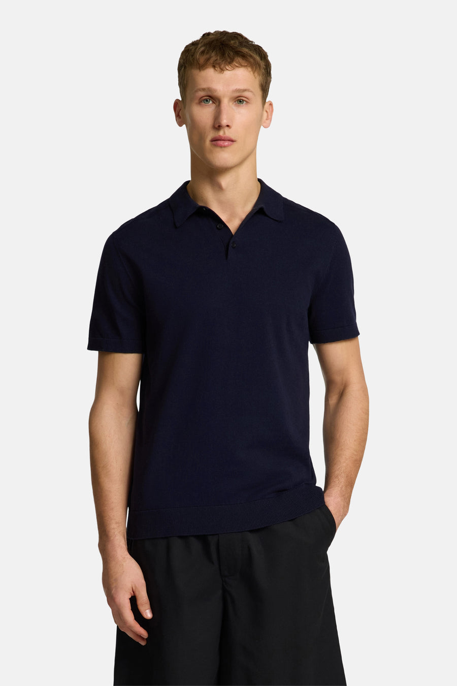 Polo bleu à manches courtes de SELECTED, porté avec un pantalon noir ample.
