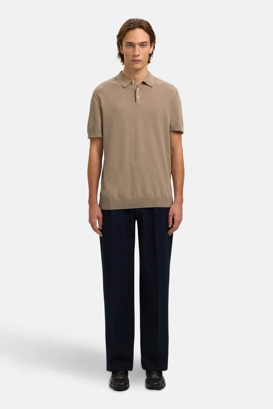 Polo brun en maille de SELECTED, porté avec un pantalon bleu marine et des chaussures en cuir marron.
