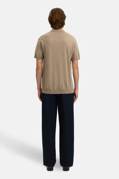 Polo brun de SELECTED, vu de dos, porté avec un pantalon ample bleu marine et des chaussures noires.