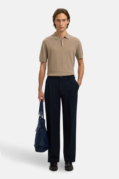 Polo brun clair de SELECTED, porté avec un pantalon bleu marine et un sac bleu.